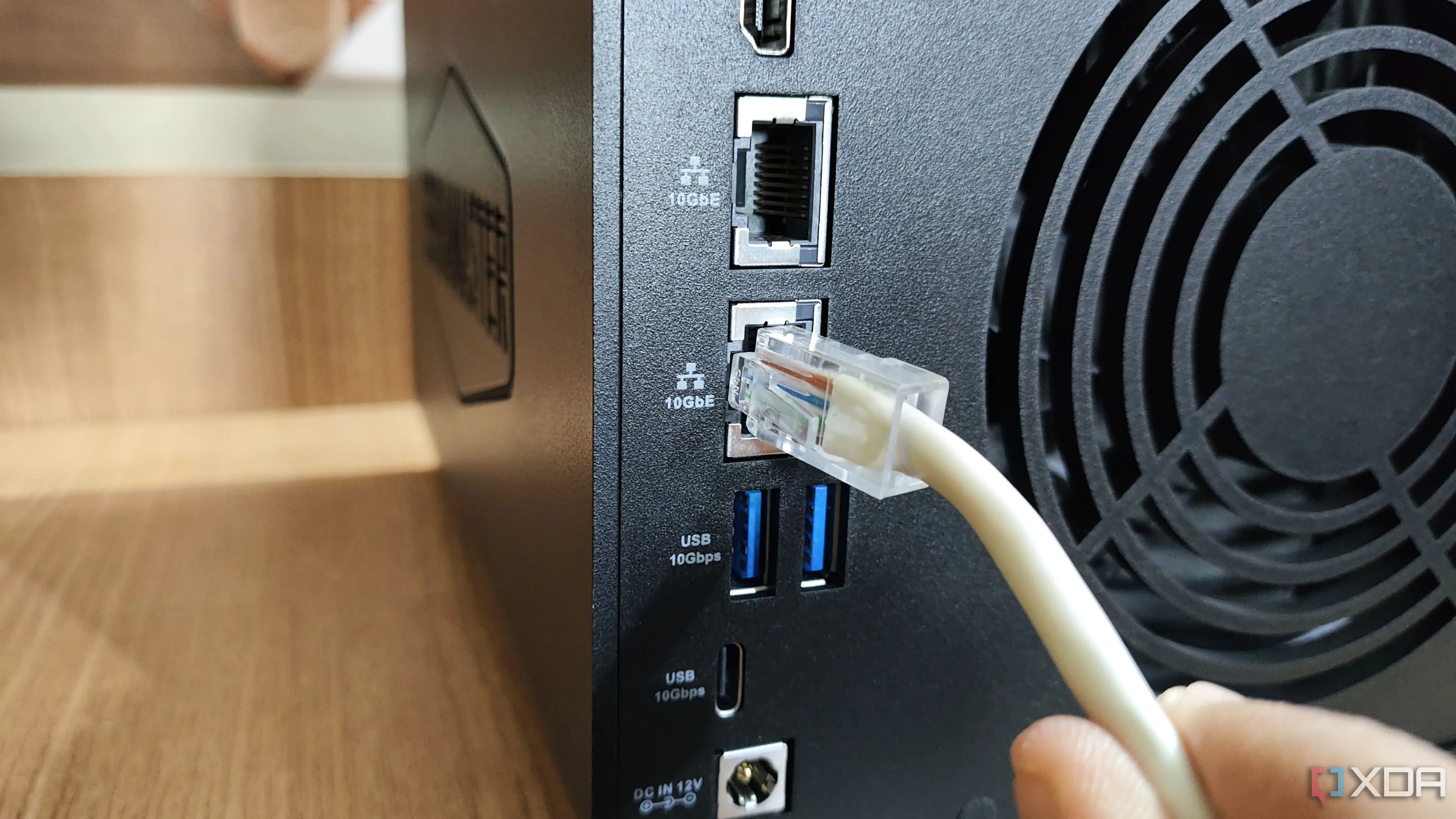 Ảnh chụp cắm cáp Ethernet vào cổng LAN 10GbE trên thiết bị NAS TerraMaster F4-424 Max, liên quan đến kết nối mạng và tiêu thụ năng lượng của NAS
