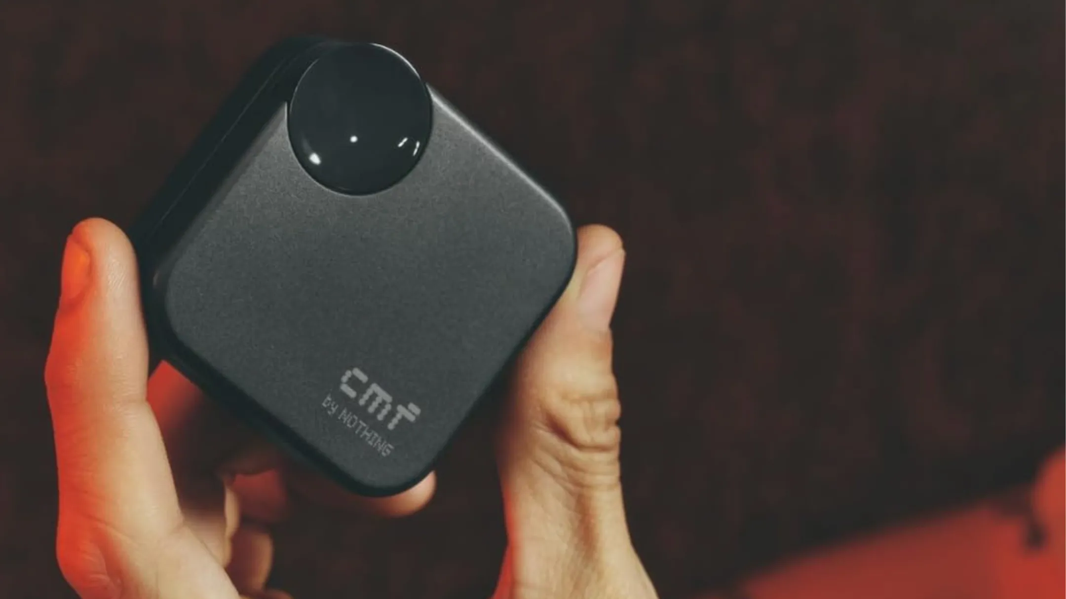 Người dùng cầm hộp sạc tai nghe không dây CMF Buds 2a màu vàng