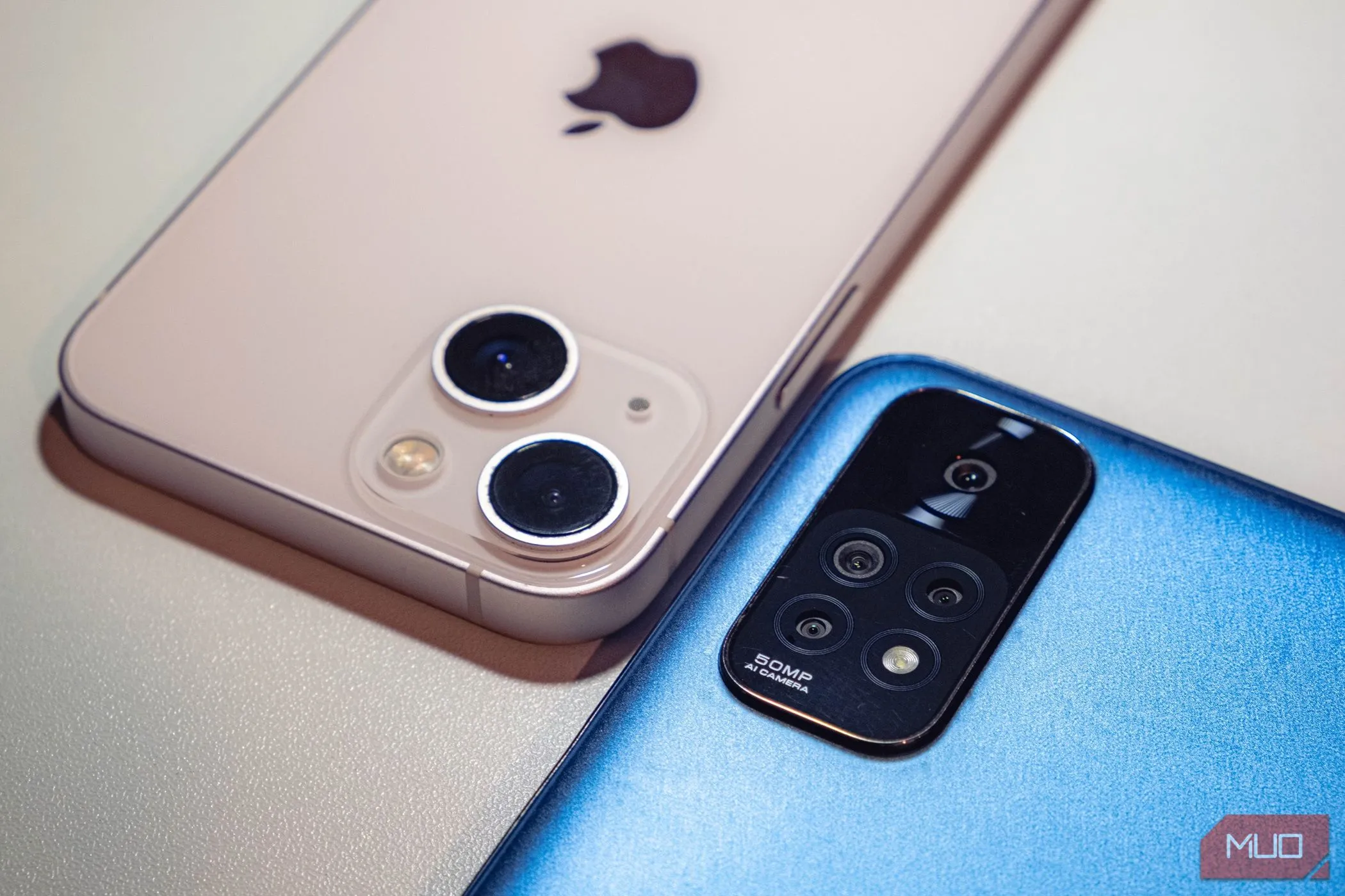 Hai chiếc smartphone màu xanh và hồng đặt úp mặt