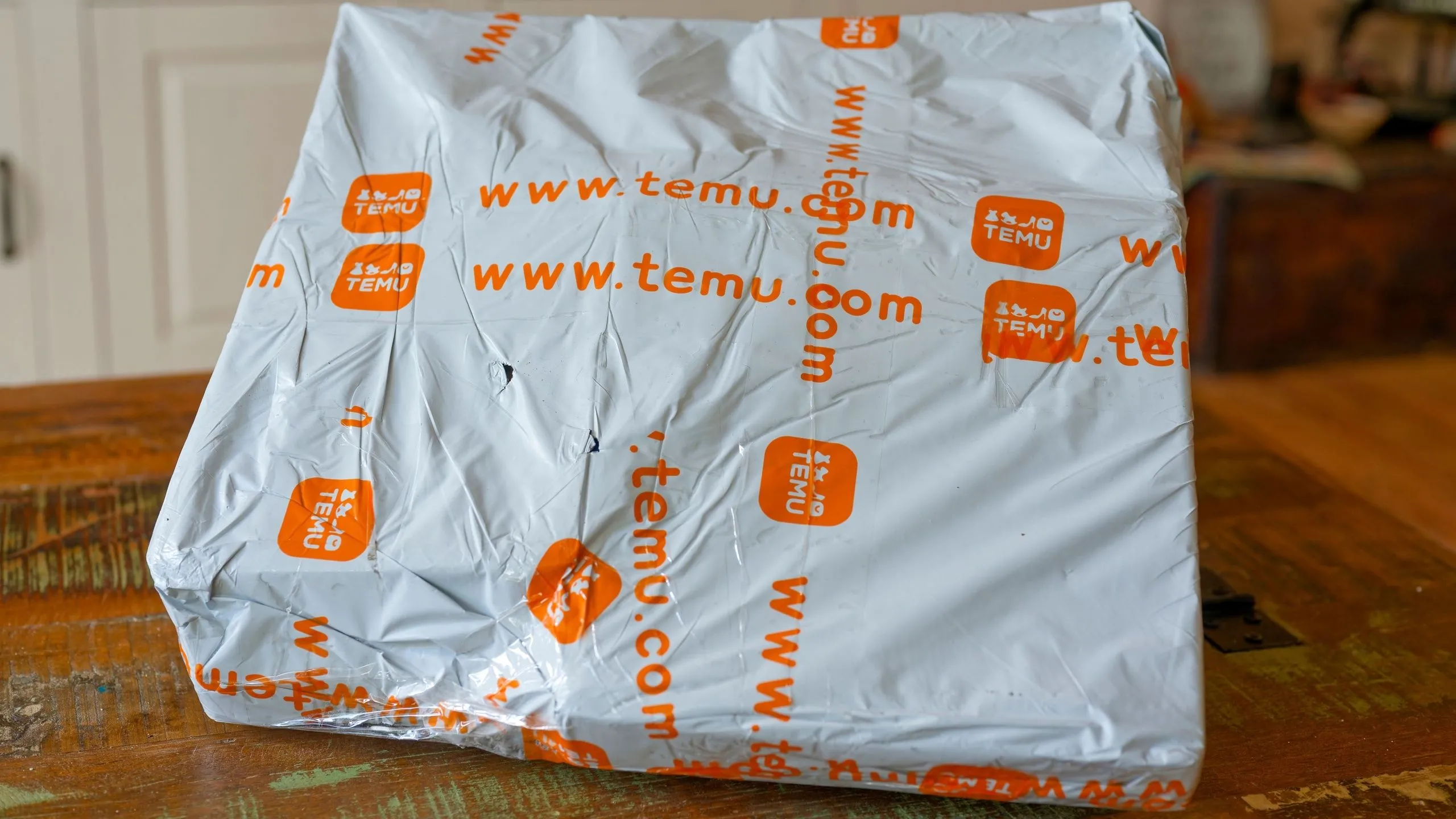 Hộp hàng Temu đặt trên bàn, tượng trưng cho trải nghiệm mua sắm trực tuyến từ các sàn thương mại điện tử quốc tế và rủi ro liên quan đến bảo vệ người tiêu dùng.