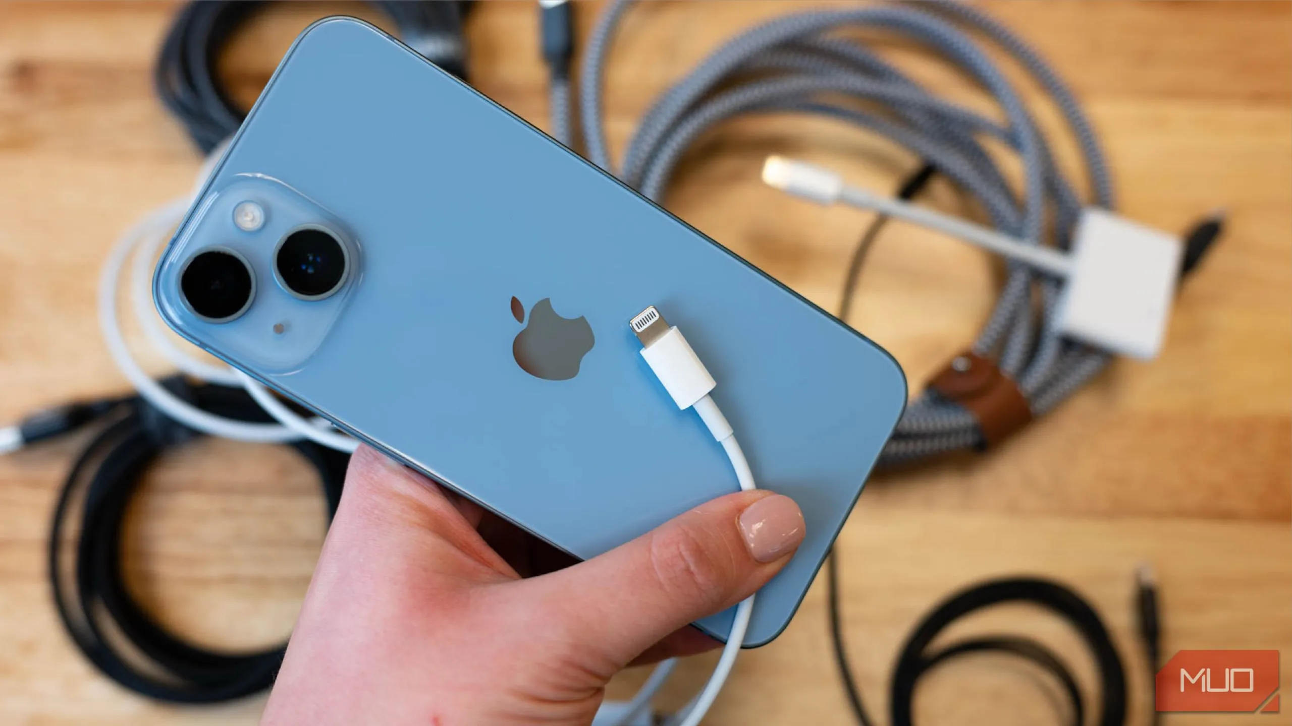 iPhone 13 đang sạc bằng cáp Lightning trên bề mặt phẳng