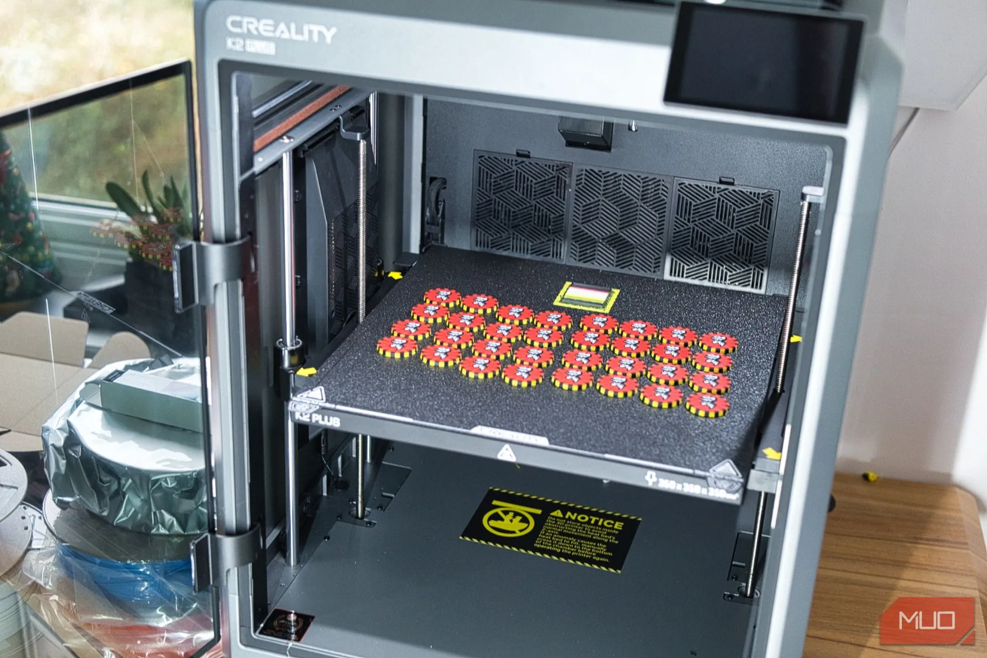 Máy in 3D Creality K2 Plus trên bàn làm việc với các mẫu in đa màu