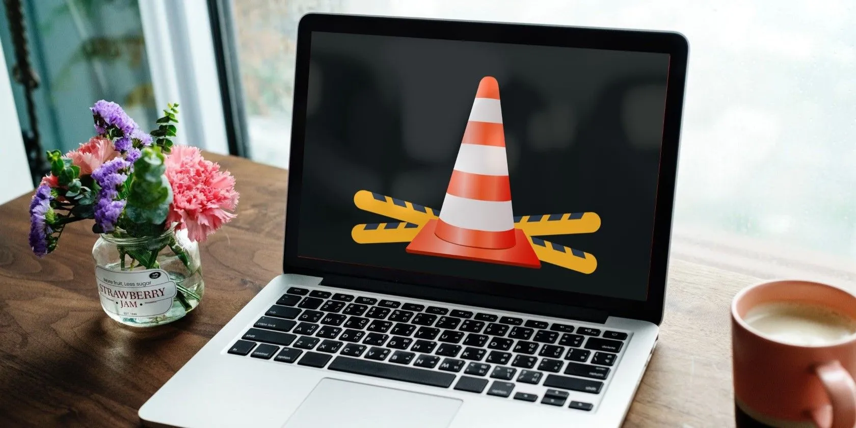 Một chiếc laptop màu bạc trên bàn gỗ, biểu trưng cho thiết bị xem nội dung