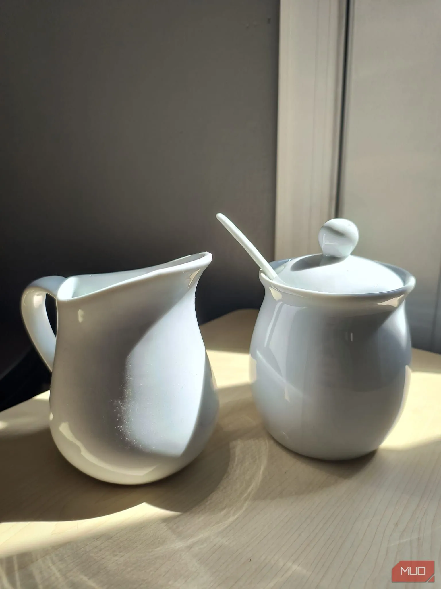 Bộ tách trà gốm sứ trắng đặt dưới ánh nắng trực tiếp, chế độ HDR bật