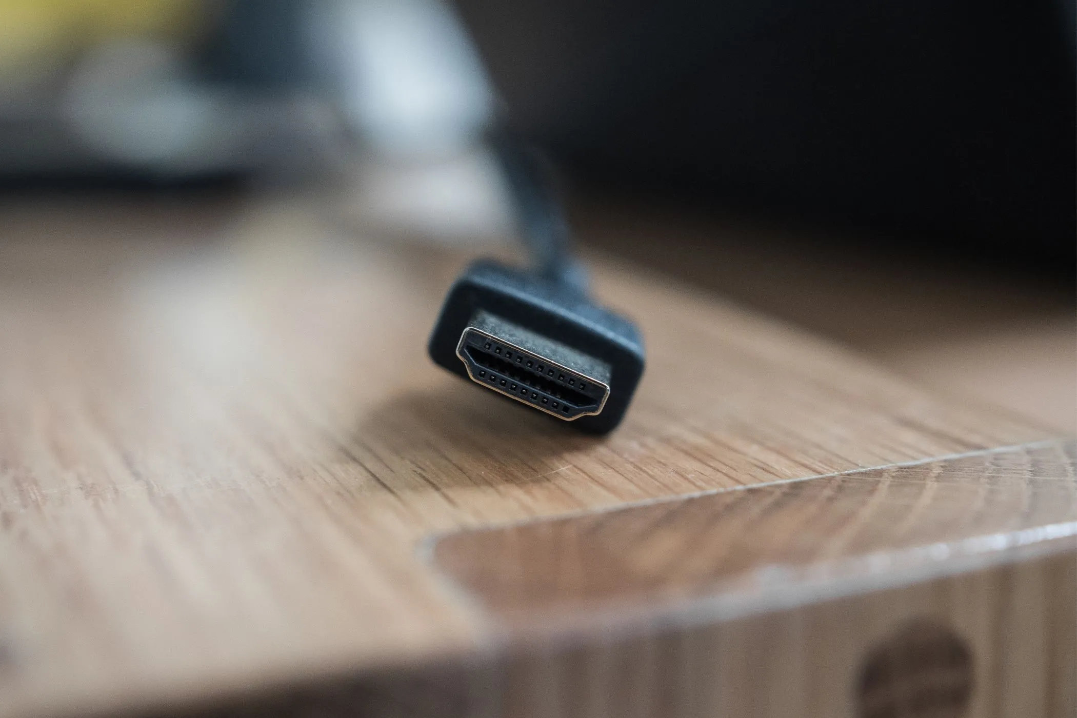 Đầu nối cáp HDMI chất lượng cao đặt trên mặt bàn gỗ.