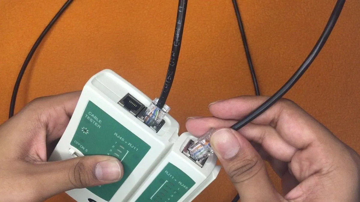 Dây cáp Ethernet được cắm vào thiết bị kiểm tra cáp mạng, minh họa việc sử dụng kết nối có dây để giảm tắc nghẽn Wi-Fi