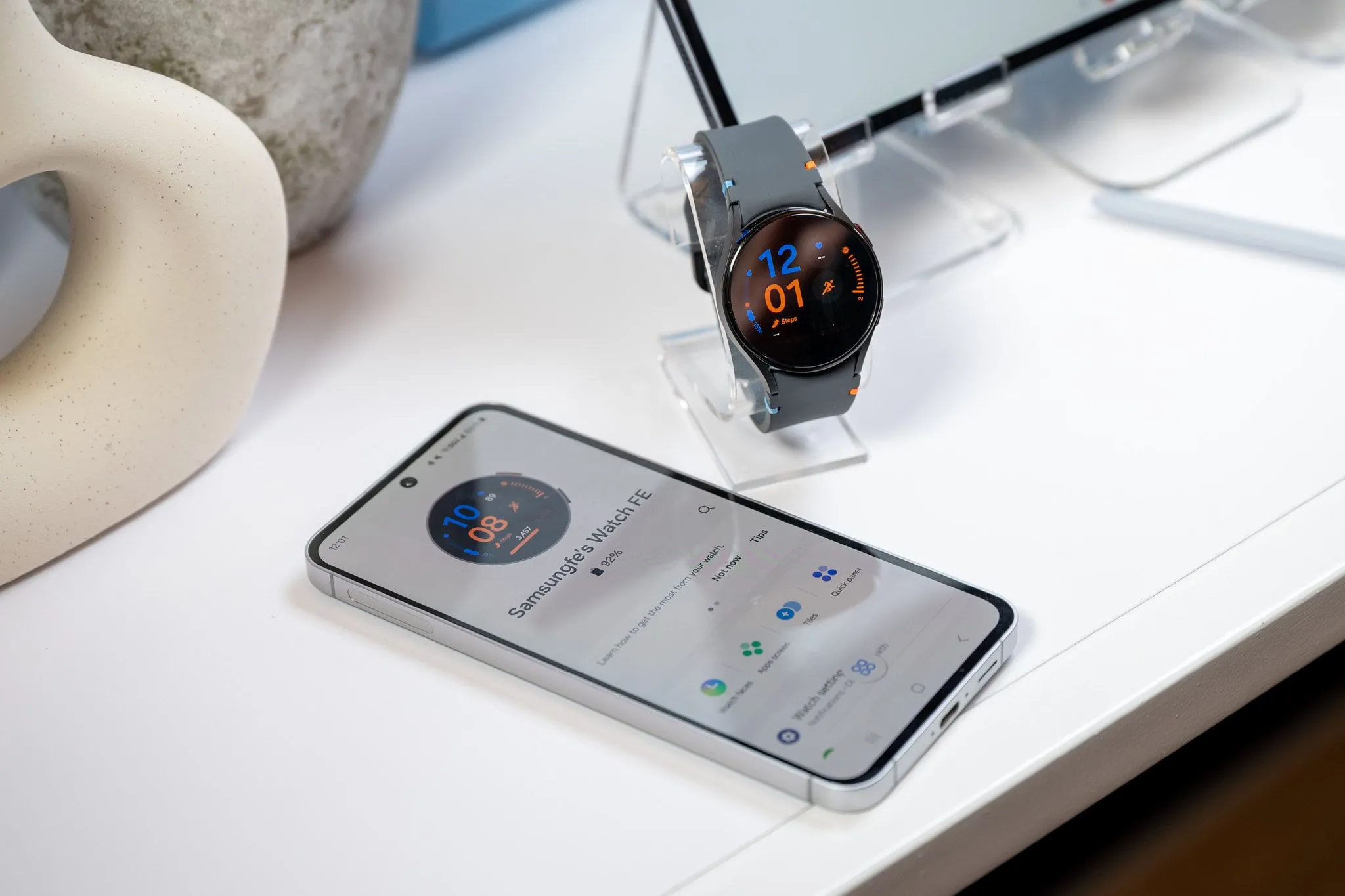 Điện thoại Samsung Galaxy S24 FE đang sạc cho đồng hồ Galaxy Watch LTE qua cáp USB-C, thể hiện khả năng sạc ngược