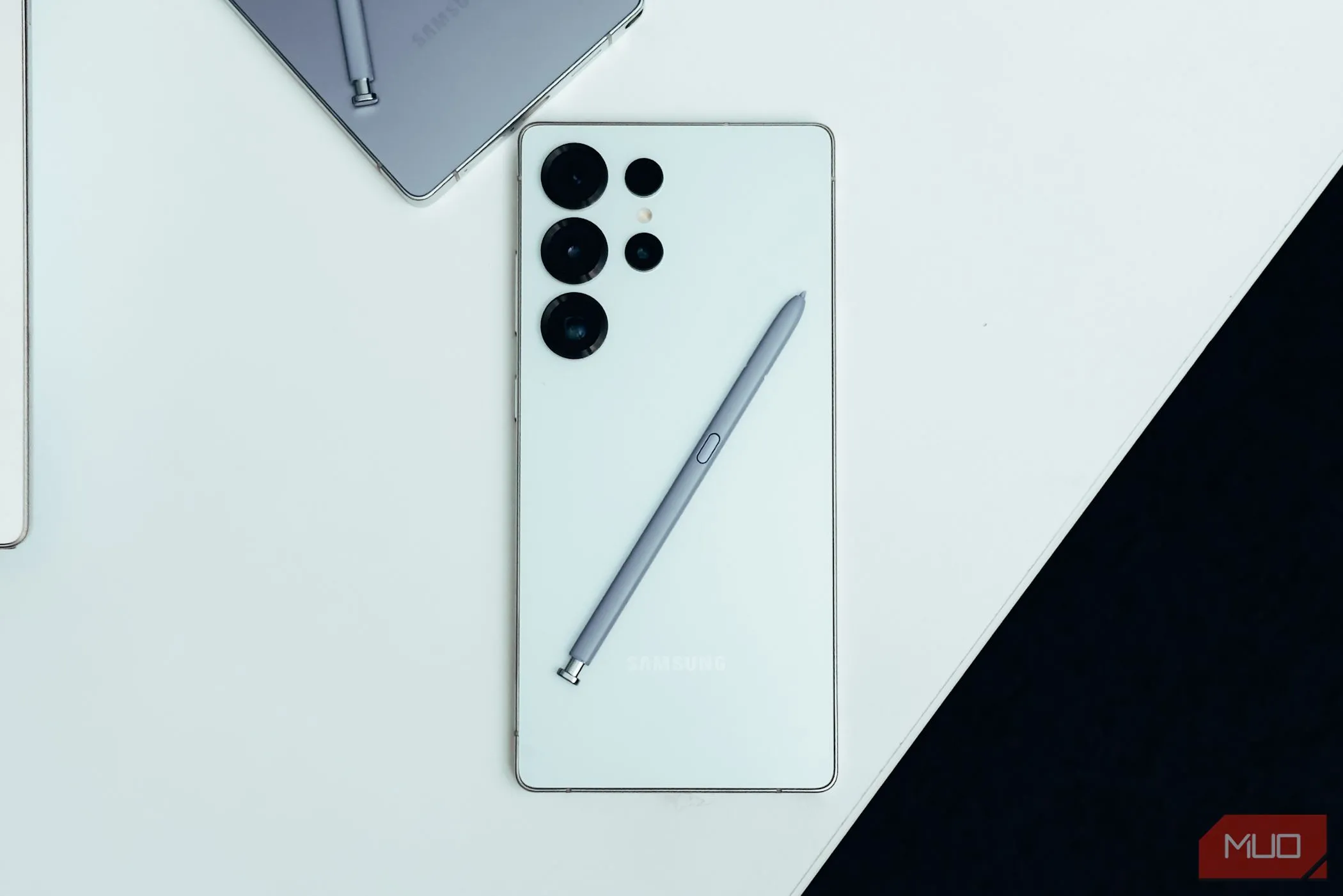 Điện thoại Samsung Galaxy S25 Ultra màu trắng đặt trên bàn, thể hiện sự kết hợp với bút S Pen đặc trưng.