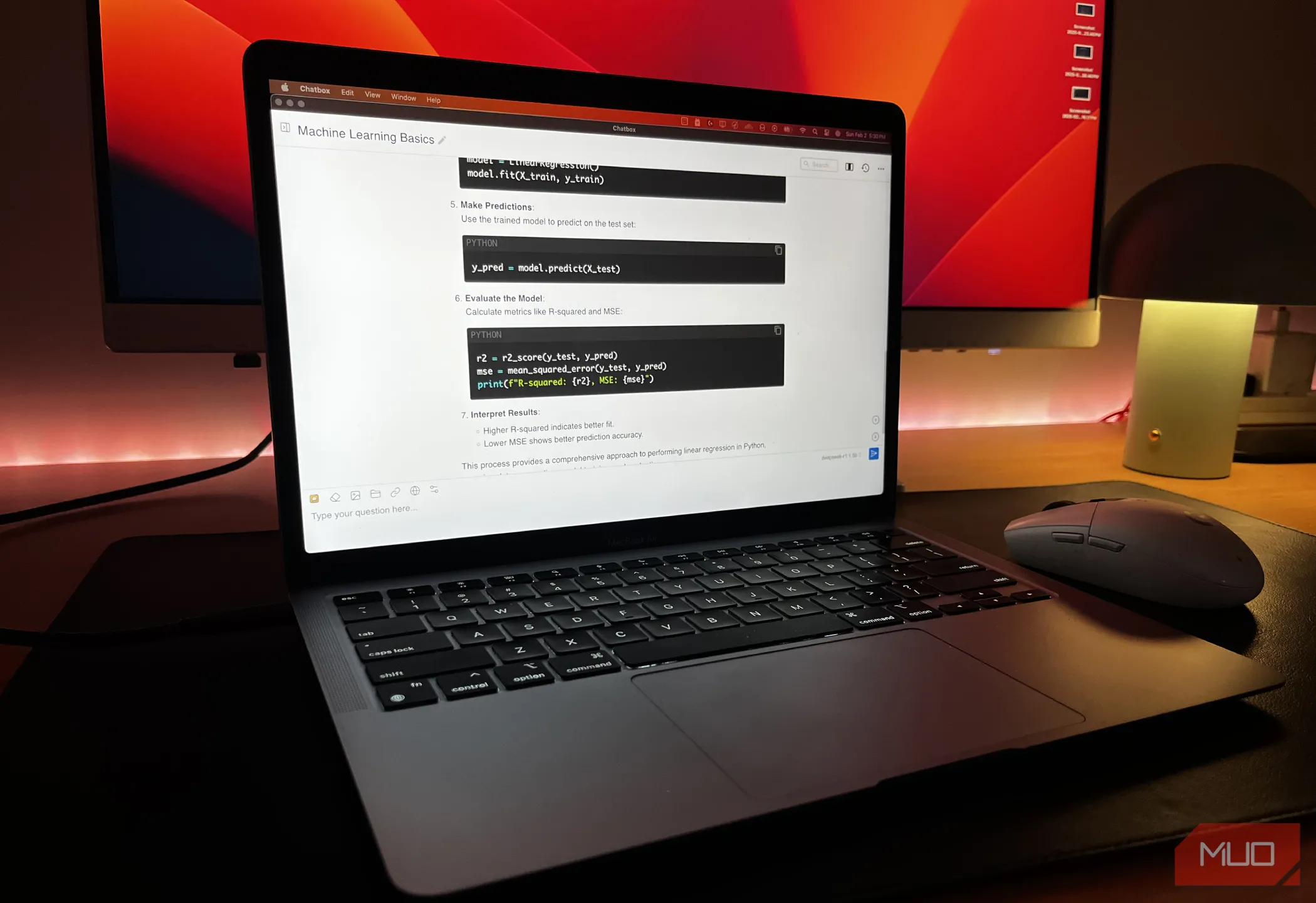 Hình ảnh một chiếc MacBook đang chạy DeepSeek R1 cục bộ, phía sau là màn hình hiển thị nội dung, minh họa khả năng cài đặt DeepSeek trên thiết bị cá nhân.