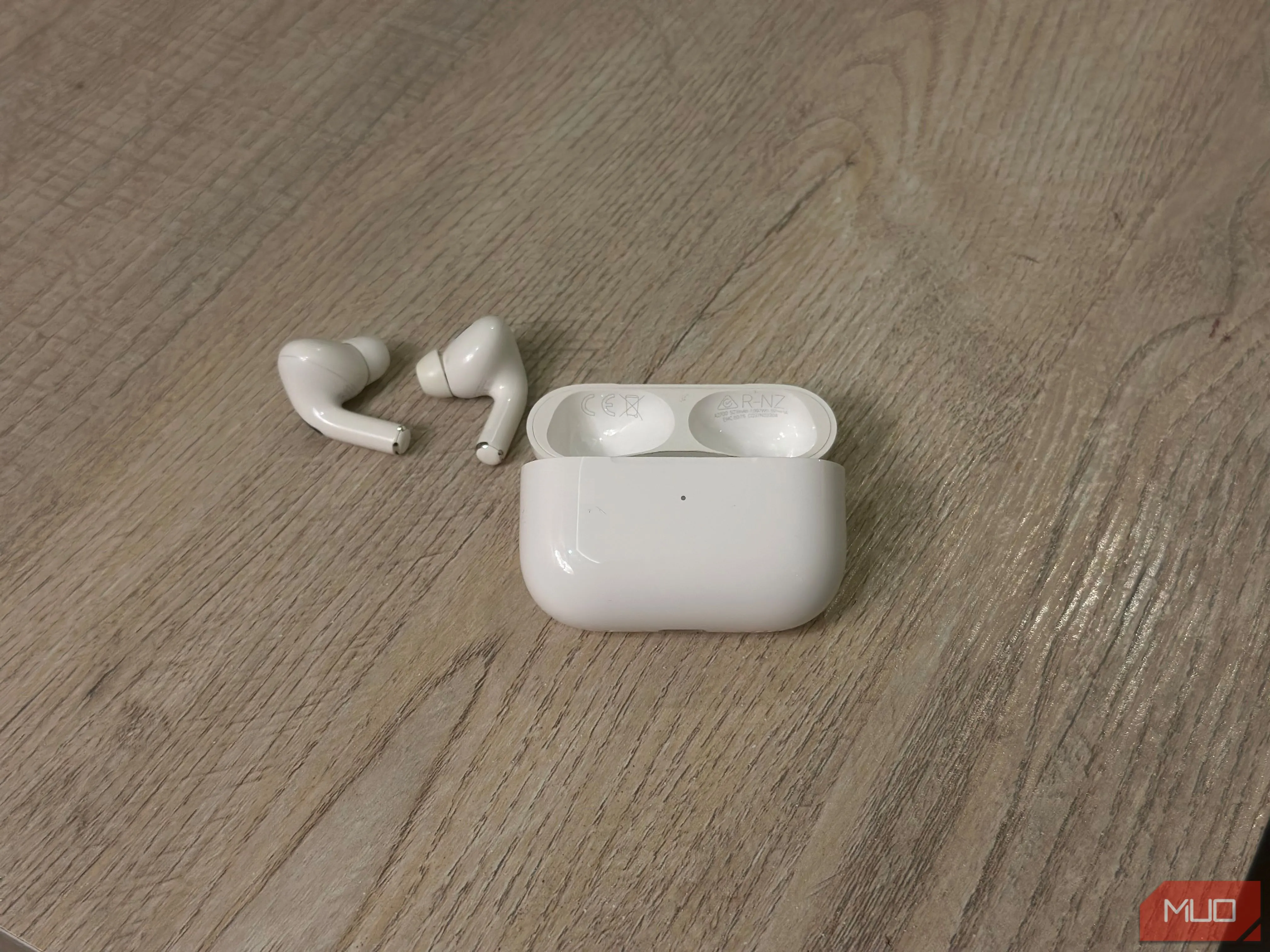 Hộp sạc AirPods mở nắp và tai nghe bên trong, cho thấy vị trí số model và serial trên nắp