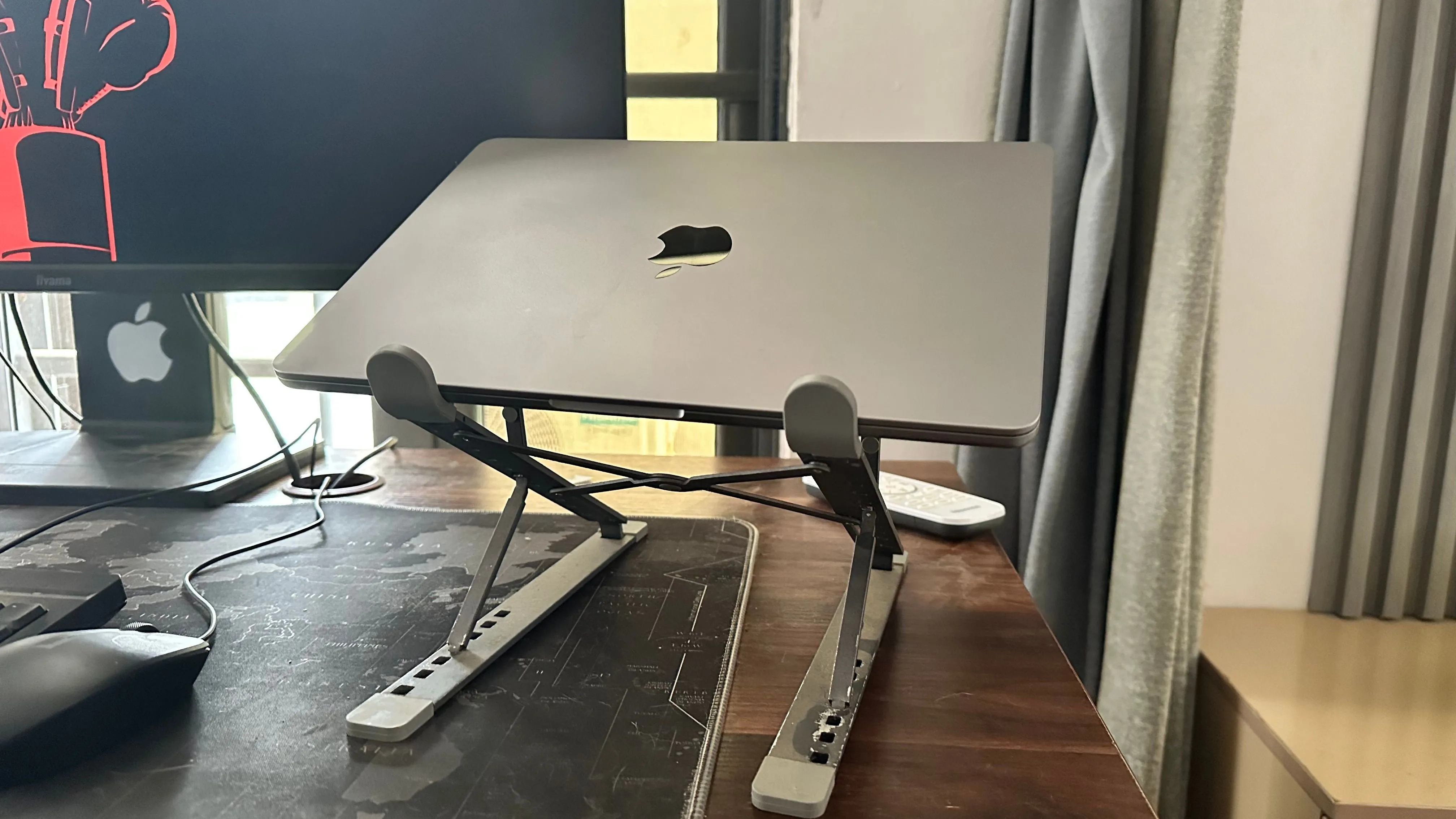 MacBook trên chân đế tản nhiệt cạnh màn hình ngoài, gợi ý giải pháp bảo vệ tuổi thọ pin
