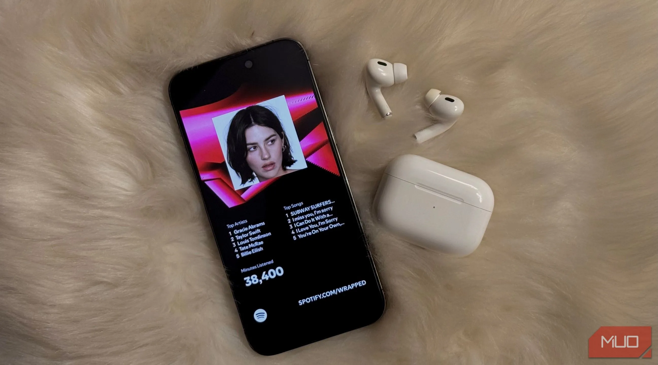Màn hình iPhone hiển thị Spotify Wrapped với tai nghe AirPods gần đó