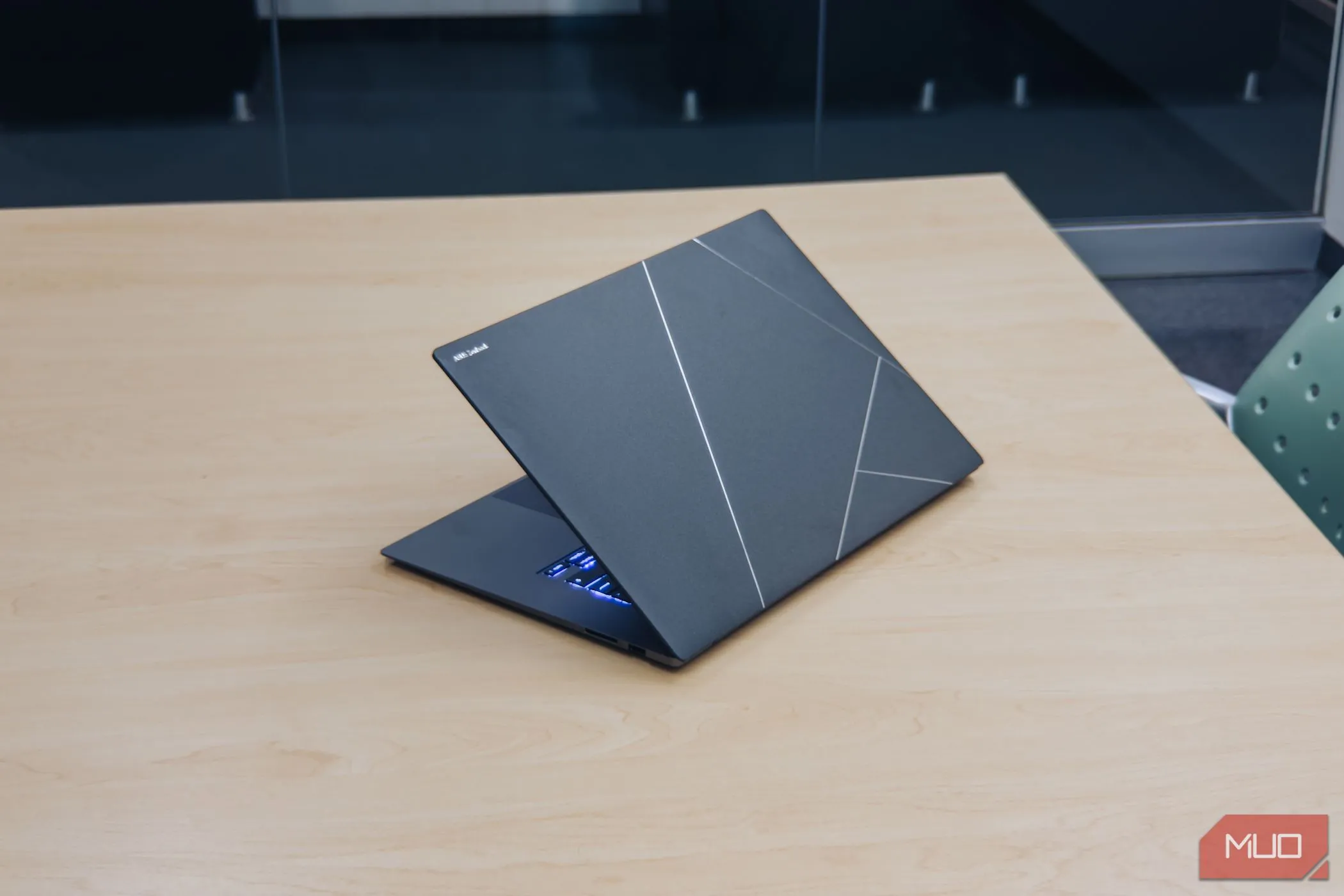 Mặt lưng Ceraluminum tinh tế của ASUS Zenbook S 16 trên bàn gỗ