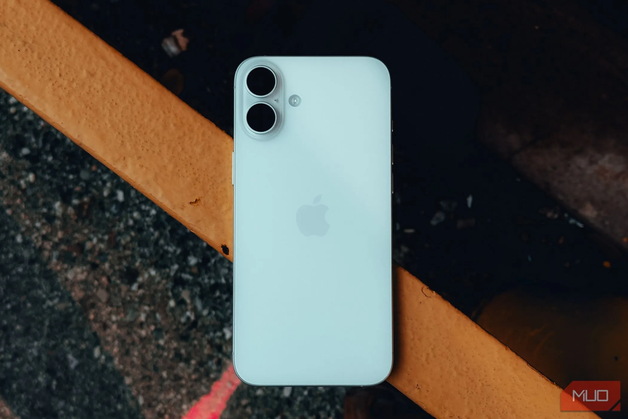 Mặt lưng iPhone 16 Plus màu xanh trên lan can nhà