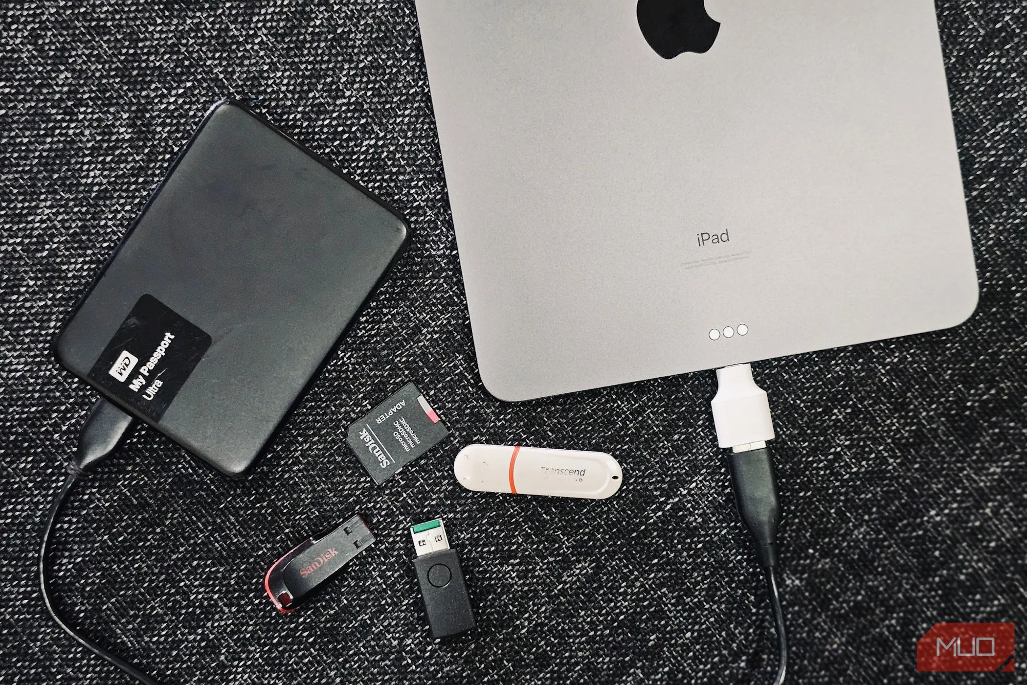 Một chiếc iPad cùng các ổ đĩa cứng gắn ngoài, minh họa việc sao lưu đa dạng.