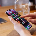 Người dùng đang sử dụng iPhone tại bàn, minh họa cách tương tác với điện thoại