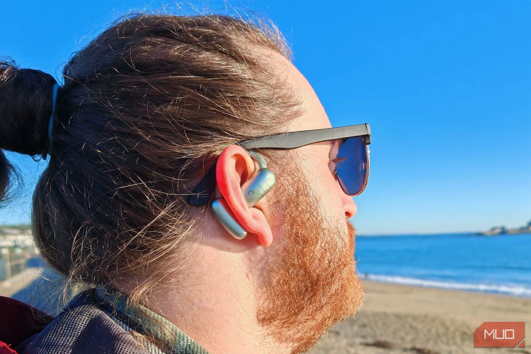 Người dùng nam đeo tai nghe Soundcore AeroFit 2 trên vành tai, thể hiện thiết kế móc tai linh hoạt