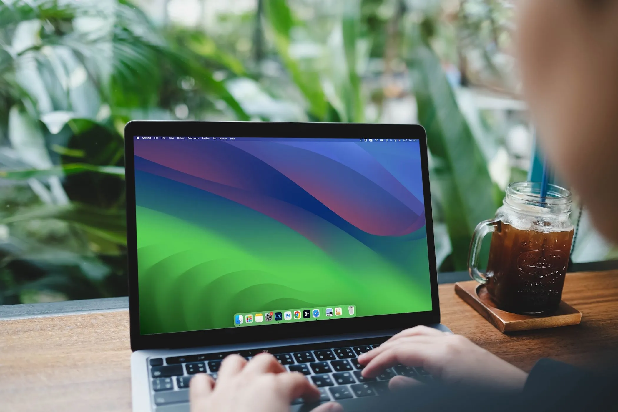 Người phụ nữ đang gõ bàn phím MacBook Air để nghiên cứu thông tin công ty