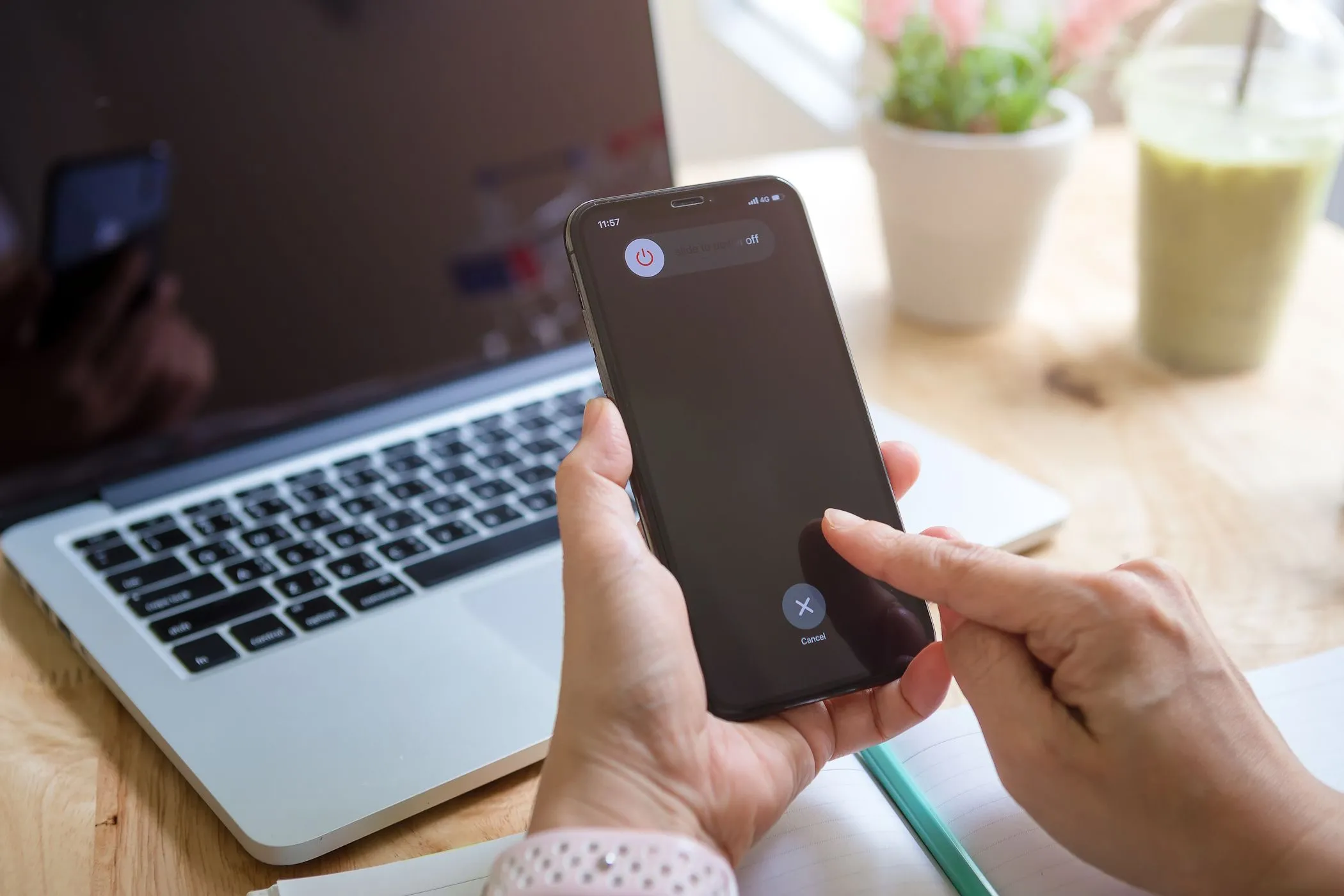 Người phụ nữ đang tắt nguồn iPhone, liên quan đến lầm tưởng về sạc pin nhanh hơn khi điện thoại tắt.