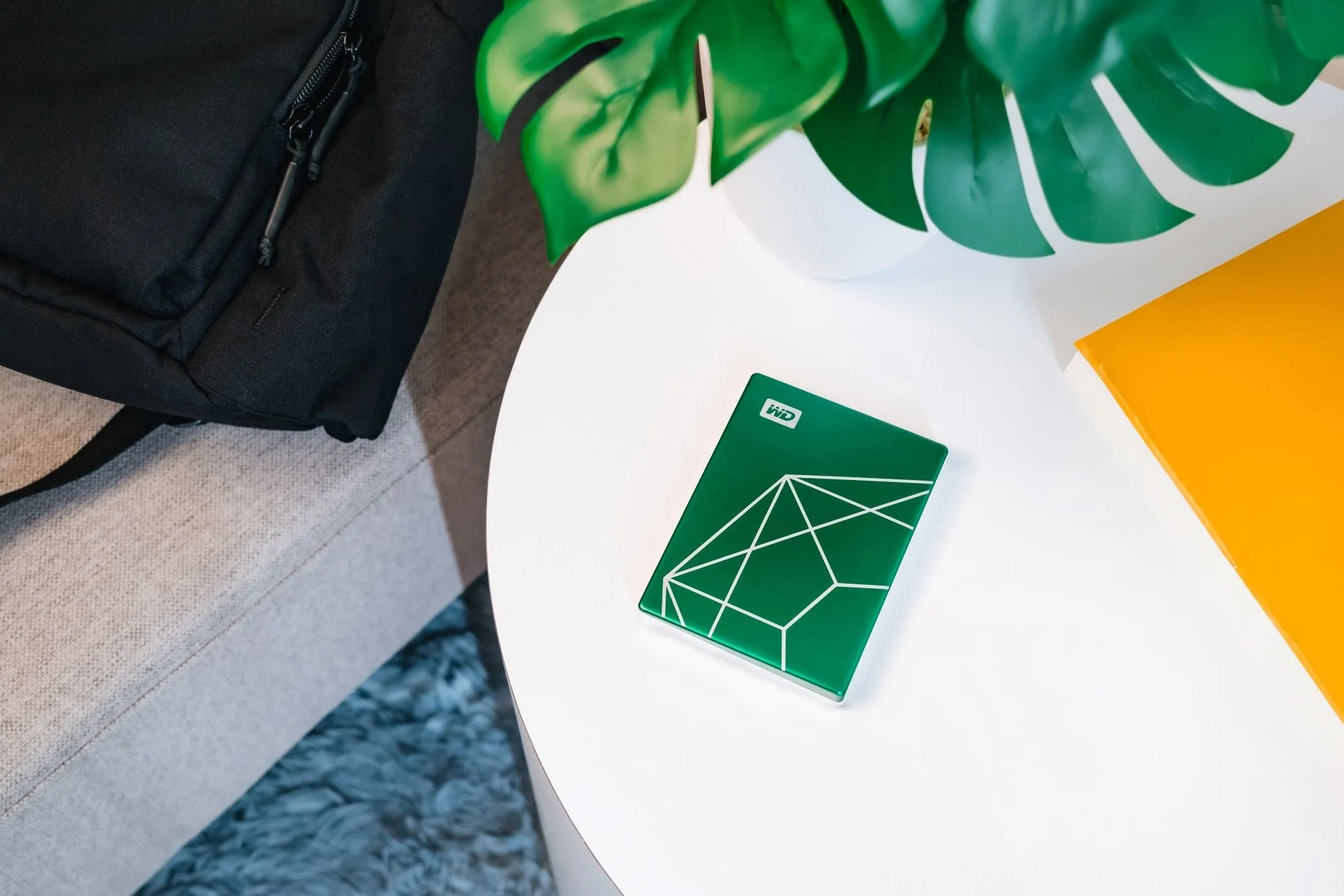 Ổ cứng WD My Passport Ultra Kỷ Niệm 20 Năm đặt trên bàn với vỏ ngoài làm từ vật liệu tái chế