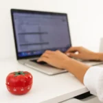 Phương pháp Pomodoro với người đang làm việc trên laptop và biểu tượng cà chua