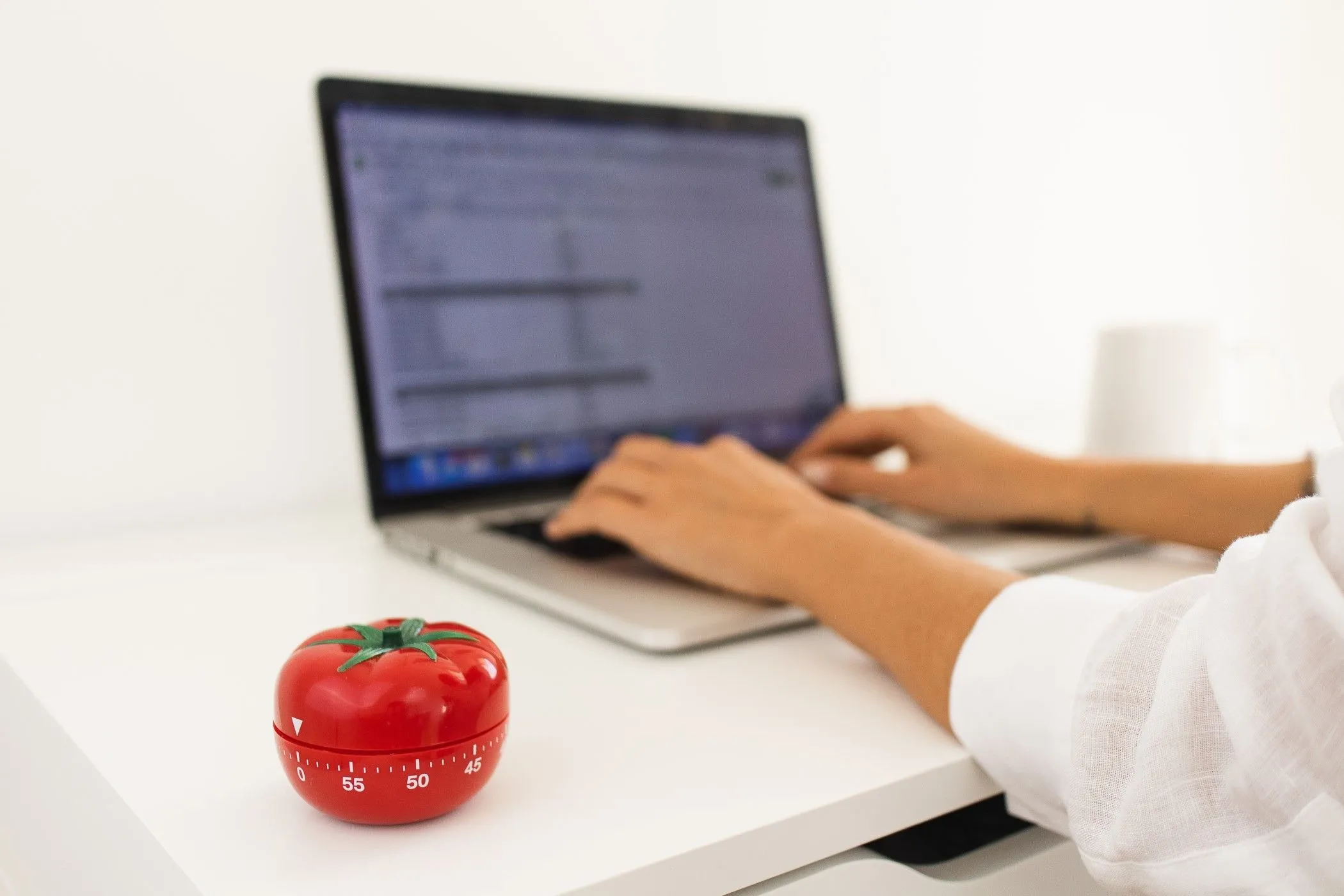 Phương pháp Pomodoro với người đang làm việc trên laptop và biểu tượng cà chua