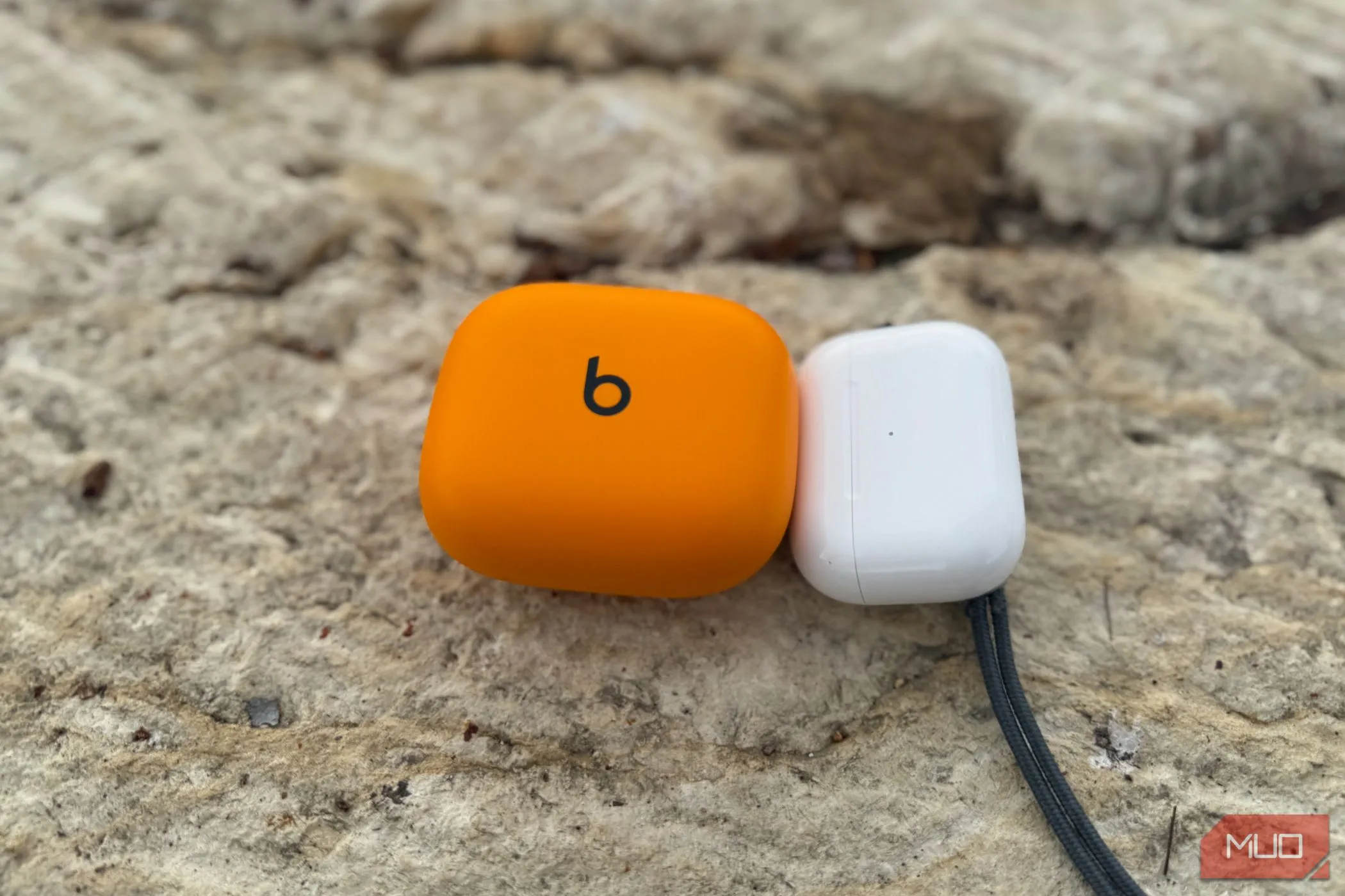 So sánh kích thước hộp sạc của Powerbeats Pro 2 (trái) và AirPods Pro 2 (phải), làm nổi bật sự cồng kềnh của hộp Beats.