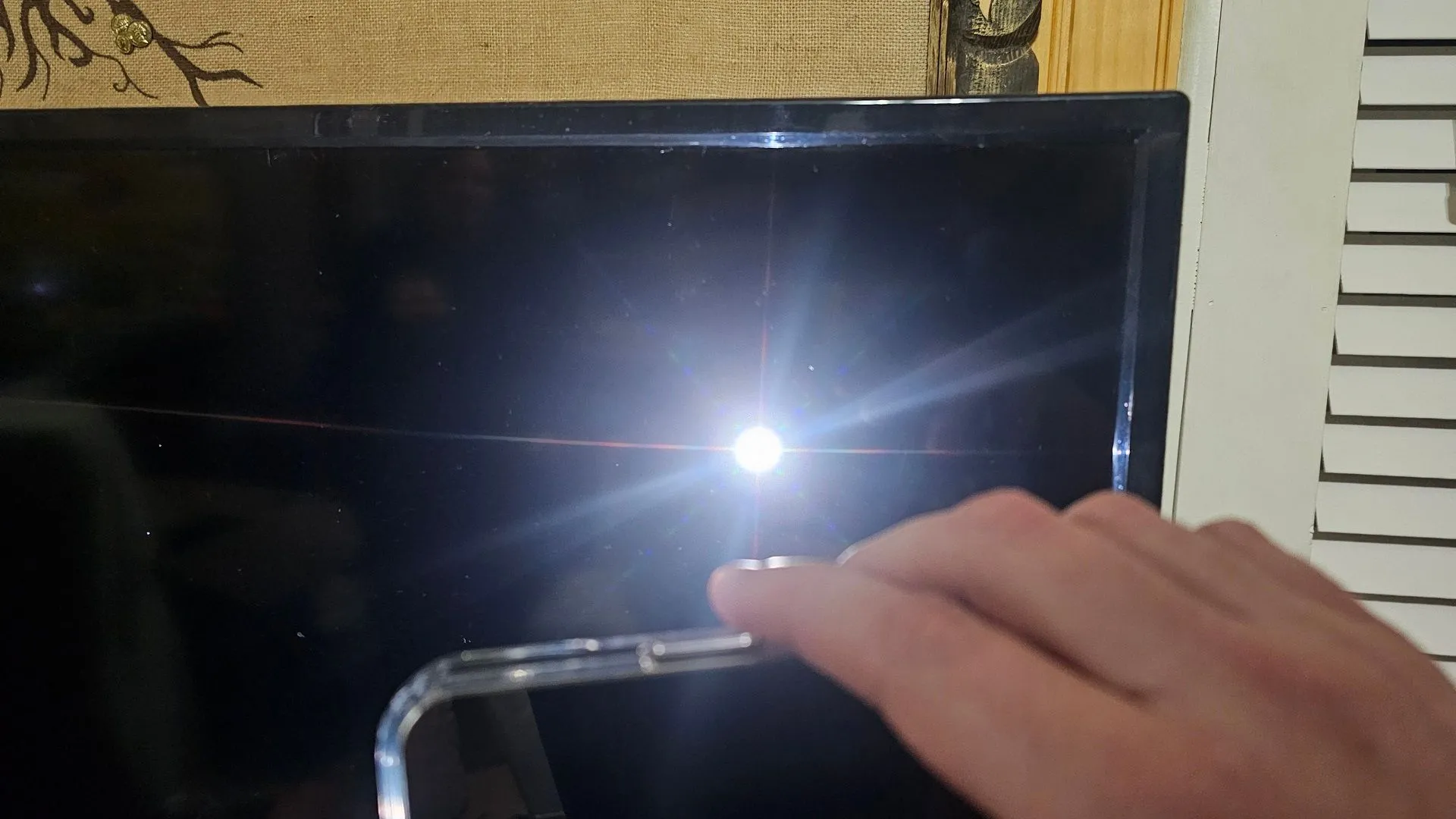 Sử dụng đèn pin chiếu sáng để kiểm tra màn hình Roku TV bị đen, tìm dấu hiệu lỗi đèn nền