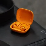 Tai nghe Powerbeats Pro 2 màu cam với thiết kế móc tai, làm nổi bật tính năng theo dõi nhịp tim hạn chế.